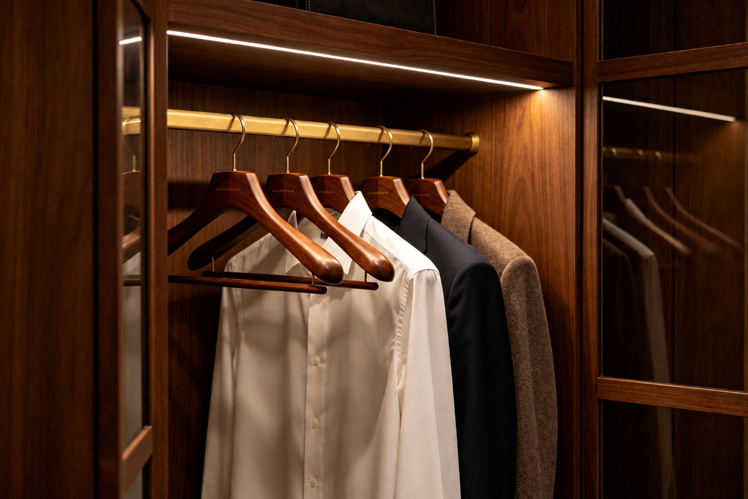 Premium wooden hangers presenting tailored garments in a luxury fashion wardrobe.