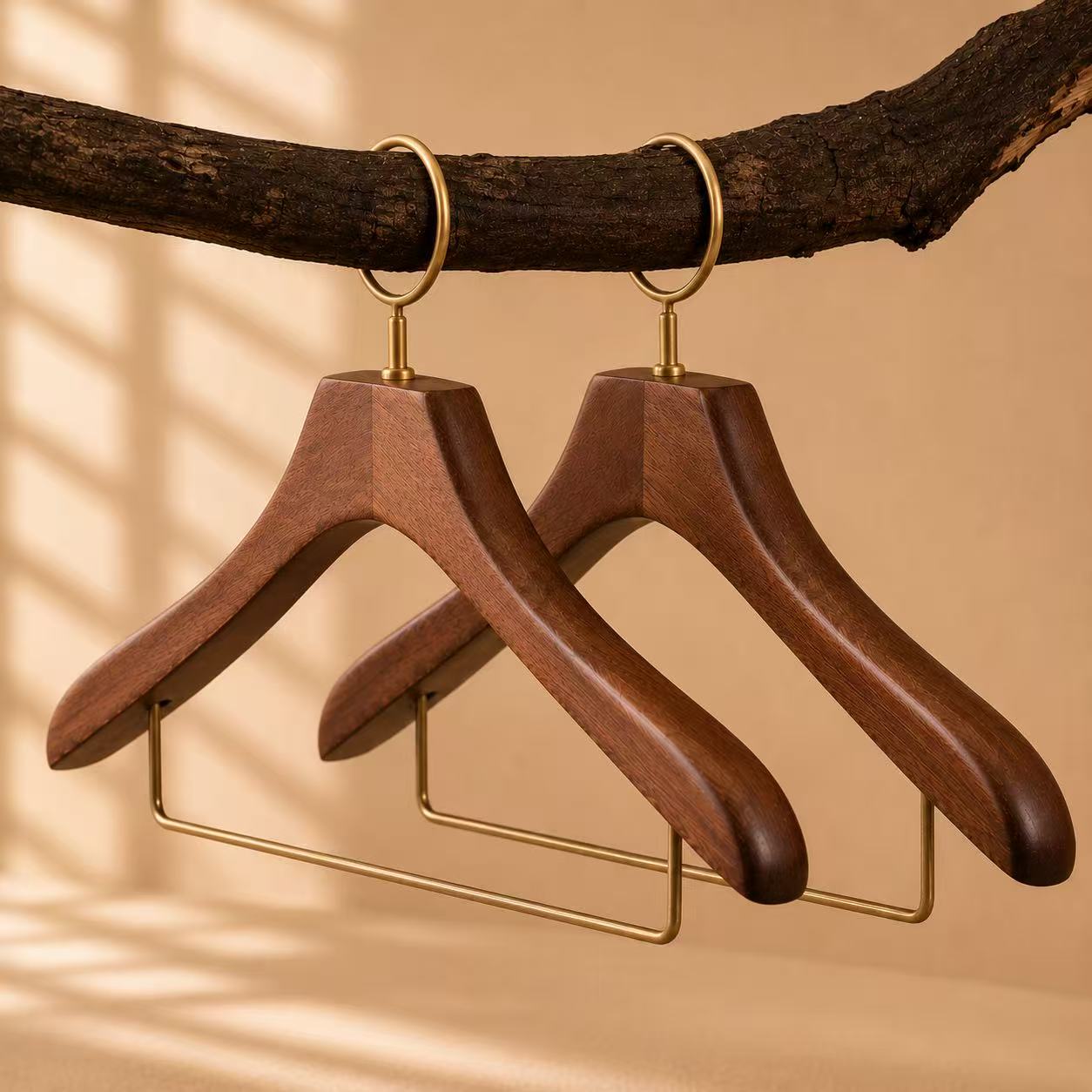 Walnut-finish hotel wooden hangers with brass security rings and trouser bars.