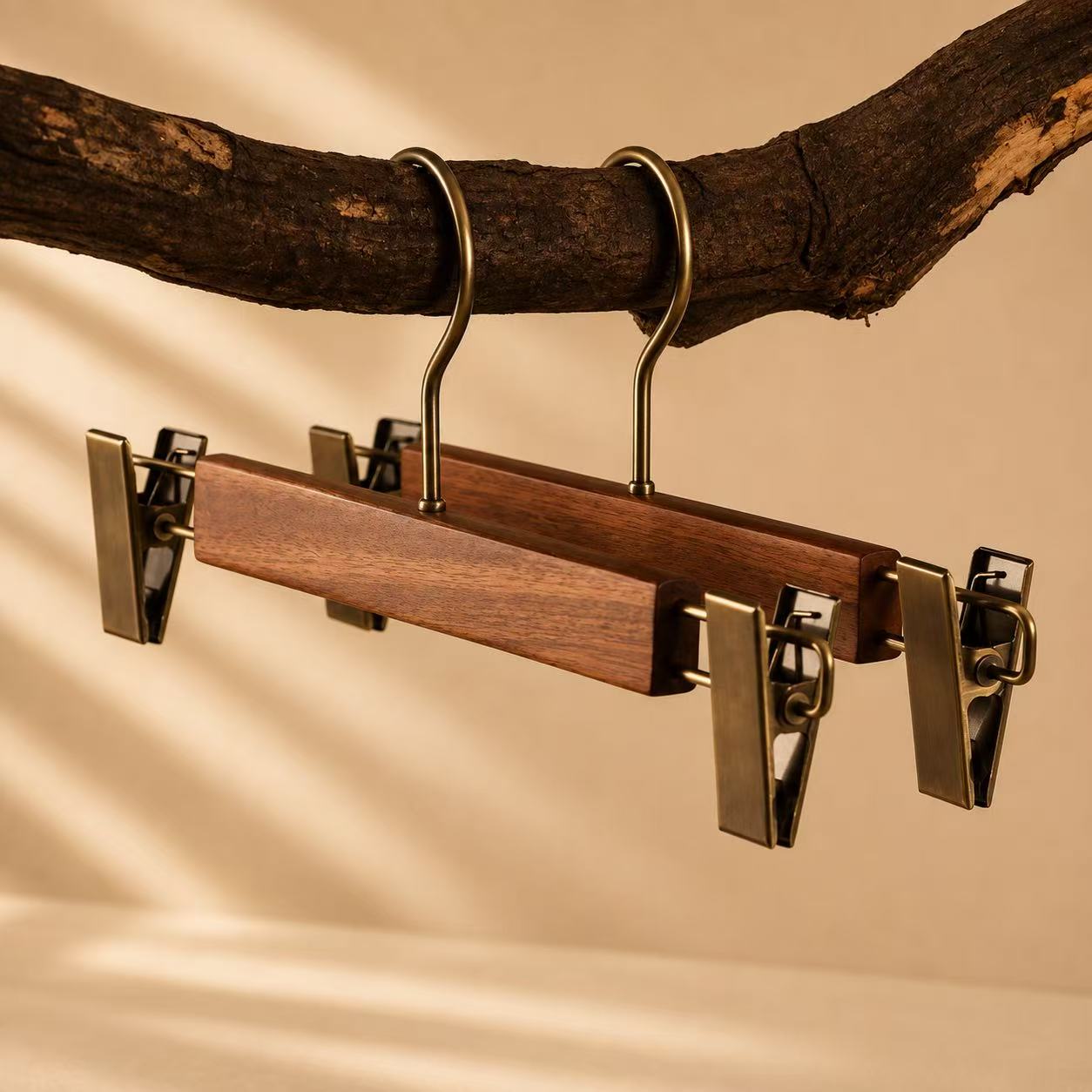 Walnut-finish wooden pants and skirt hangers with brass metal clips.