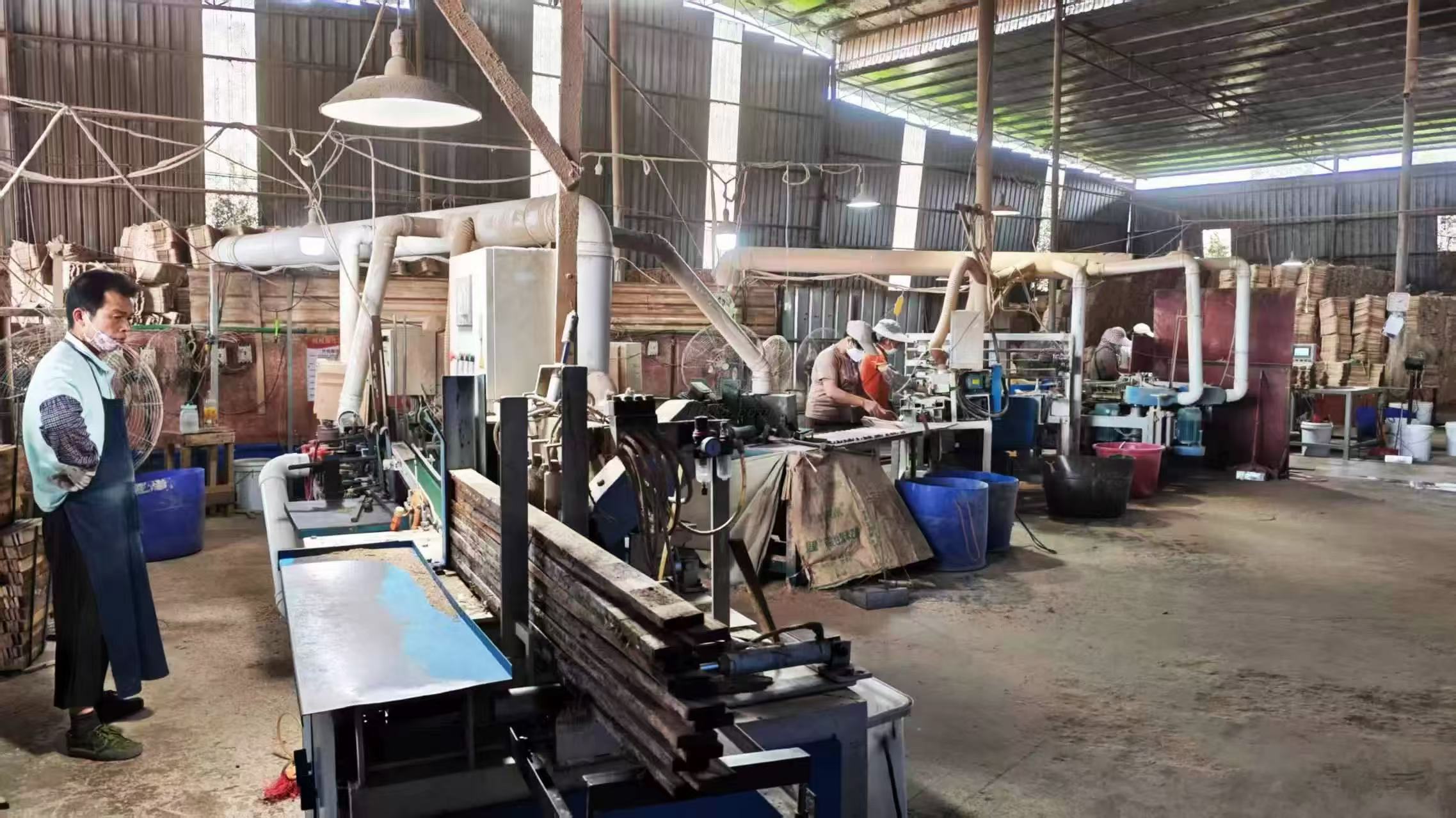 Wooden hanger workshop with machinery and workers.